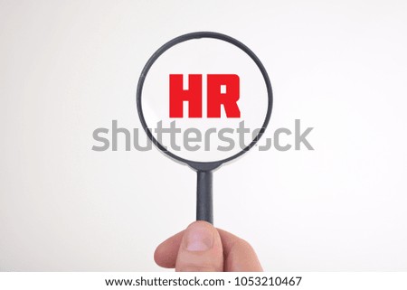 Businessman looking at a magnifying glass word:HR