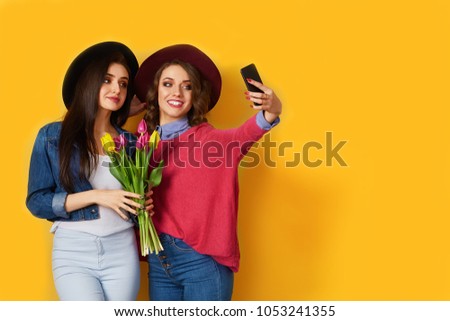Young beautiful and fashionable women in nice spring or summer dress. Spring/ summer concept on yellow background