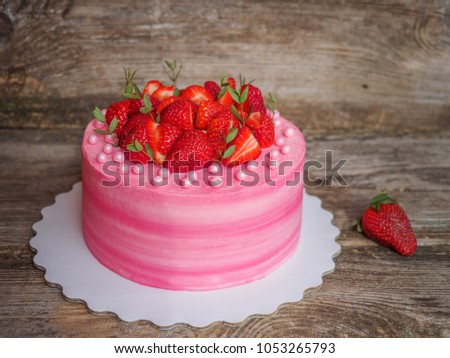 homemade tender pink cake with curd cream and strawberries on the table