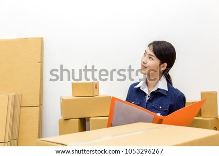 Asian woman working own business retail product stock in box package SME home office.