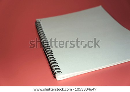 White notebook on a pink backgroud