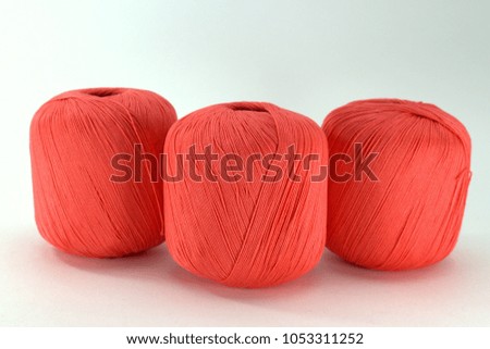 Three bright pink tangle of natural cotton for needlework on white background close-up