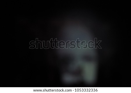 The blurred white face against a dark background. Mystical blurred background.