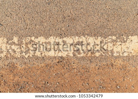 old dirty white line on surface of old asphalt in countryside