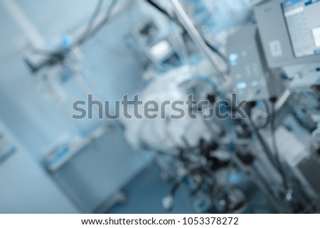 Blurred hospital ward with silhouette of human in the bed, unfocused background.
