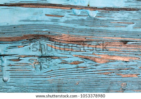 Old wooden background with remains of pieces of scraps of old paint on wood. Texture of an old tree, board with paint, vintage background peeling paint. old blue board with cracked paint, vintage