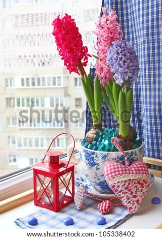 Beauty hyacinths and lantern with a conflagrant candle on a window Royalty-Free Stock Photo #105338402