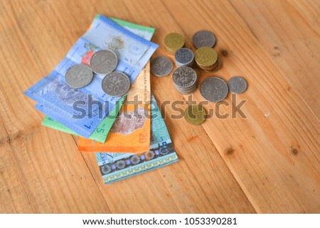 Mixed value of Malaysian Ringgit Bank Notes and Coins on wooden background. selective focus.