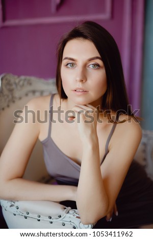 Portrait of young woman in nightgown to sleep, looking camera.