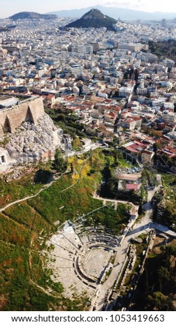 Aerial drone bird's eye view photo of iconic ancient theater of Dionysus in Acropolis and Lycabettus hill at the background, Athens historic center, Attica, Greece