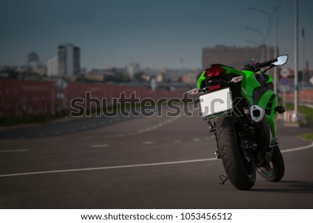 Green motorcycle in the parking lot in the evening Royalty-Free Stock Photo #1053456512