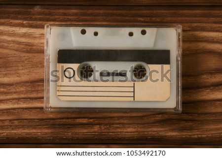 Blank cassette tape box on old wooden table background. Vintage cassette tape case with retro cassette mockup. Plastic analog magnetic clear packaging template. Mixtape box cover.