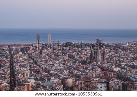 This is the spectacular view of Barcelona, Spain. In the picture it can be spotted the Sagrada Familia (Sacred Family of Antoni Gaudi­), the Mapfre towers, and many more monuments. It is almost night.