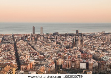 This is the spectacular view of Barcelona, Spain. In the picture it can be spotted the Sagrada Familia (Sacred Family of Antoni Gaudi­), the Mapfre towers, and many more monuments. It is sunset time.