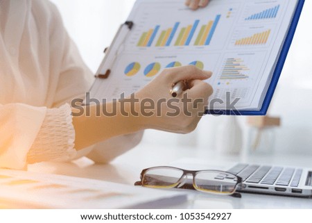 young working woman  reading  report graphs document at work