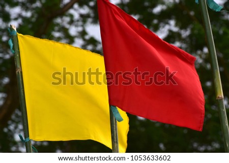 Red & yellow flying textile made flags with natural background unique stock photo