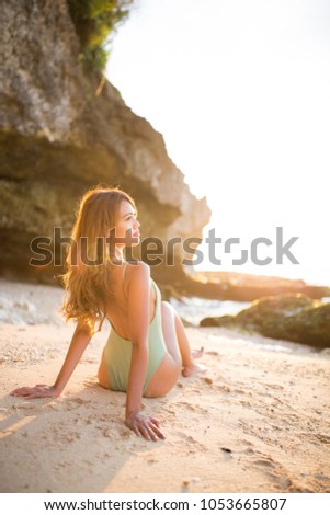 Young girl relaxing on a tropical beach at sunset