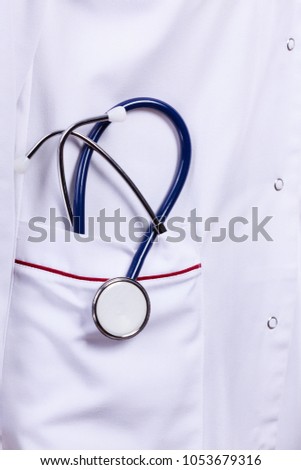 Medical examinations concept. Doctor uniform with blue stethoscope in pocket. Close up professional medic tool.