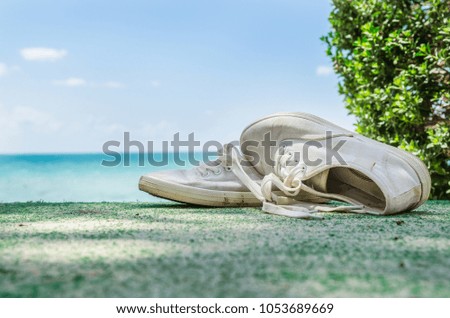White shoes are on the beach.