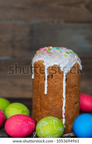 Easter cake decorated with white icing and colorful sugar on a wooden background