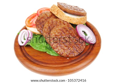 several large roast hamburger with loaf on wooden plate isolated over white background