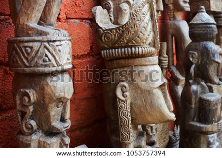 Group of different  Balinese wooden statues displayed in art and craft tourist market. Indonesian handicrafts. Souvenir from Bali. Traditional wood carving. Ð¡ounter with balinese souvenirs.
