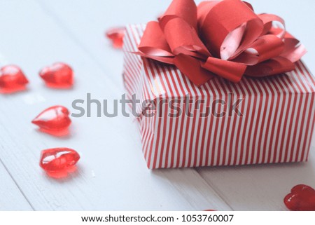 gift box with red bow and hearts on light background