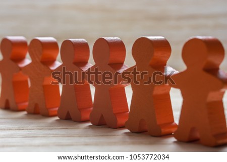 Human chain of wooden figures as a sign of peace and cohesion Royalty-Free Stock Photo #1053772034