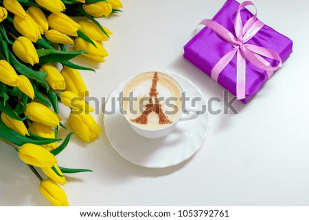 Cappuccino in Paris white cup with yellow tulips and a gift