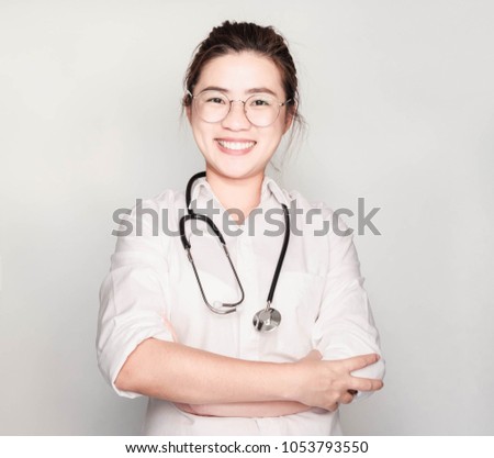 Portrait friendly, smiling, confident female doctor, health care professional, Happy young nurse standing folded arms with stethoscope  isolated on gray background