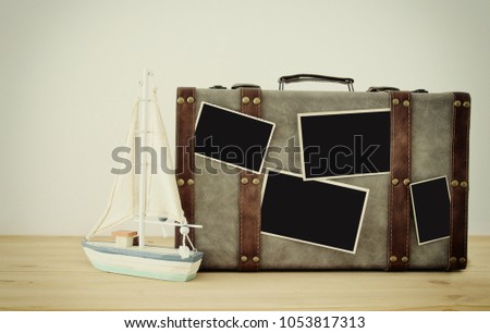 Image of old vintage luggage, vintage boat and blank photos for photography montage mockup over wooden floor
