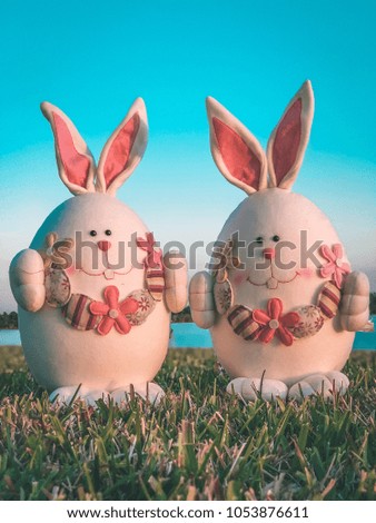 Easter bunnies in the grass, blue sky.