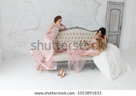 brides taking selfie while playing on sofa and drinking champagne