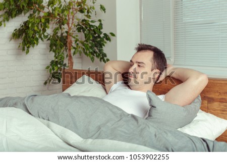 Young Man Sleeping On Bed In Bedroom