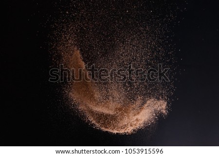 abstract sand explosion art on black background, sand splash Royalty-Free Stock Photo #1053915596
