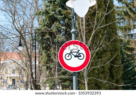 Bicycle road street sign on street light pylon on a bright sunny day.