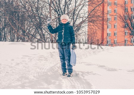 A boy in ski clothing indulges in a snow hill, winter snow frosty weather