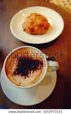 White cup of coffee with scone on a wooden table. instagram style toned image for good morning quotes