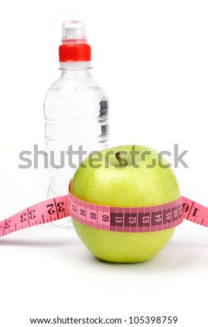 An image of green apple with tape and  bottle on background