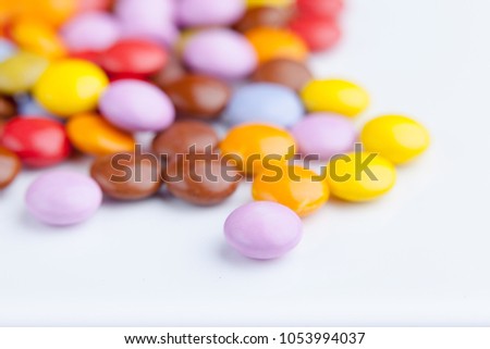 A lot of colorful chocolate candy top view, occupying the whole picture. White background.