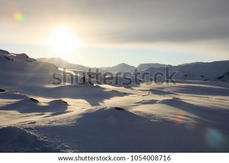 Winter time, snow shore, Russia, landscape of beautiful wild nature of north sees. Beautiful snow winter ice and cold landscape, picturesque view with mountains on horizon, sky clouds, sun lens flare