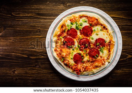 Pizza salami on wooden background