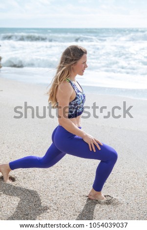 fitness, sport, training, gym and lifestyle concept - young woman stretching on the beach