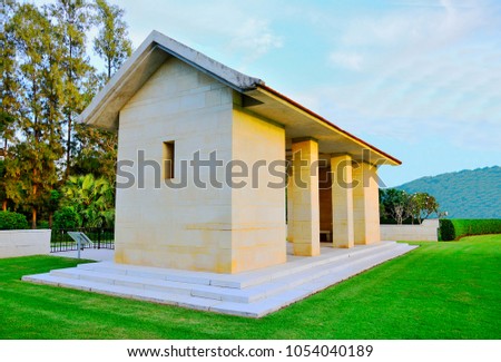 Close up of White pavilion in public park on  grass field has mountain and sky background