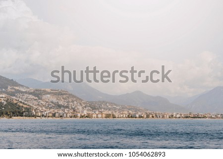 the coastline on the background of the city and mountains