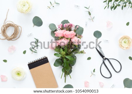 Small bouquet of pink bush roses in a woman's hand on a white background, top view, flat lay, copy space