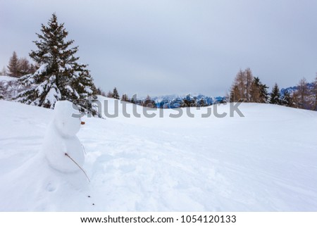 Lonely snowman with Dolomites mountains in the background, Col Visentin, Belluno, Italy