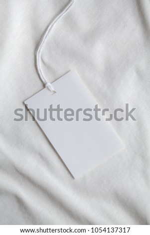 Clothes label tag on cloth background blank white branding template mockup