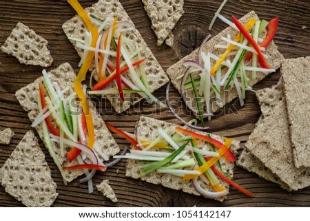 Healthy sandwiches with fresh vegetables. Breakfast toasts on wooden cutting board. Balanced breakfast.