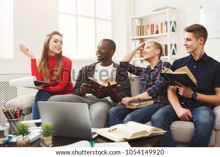 Multiethnic university students studying together. Young people working with tests and gadgets, sitting on the couch. Education and technology concept, copy space